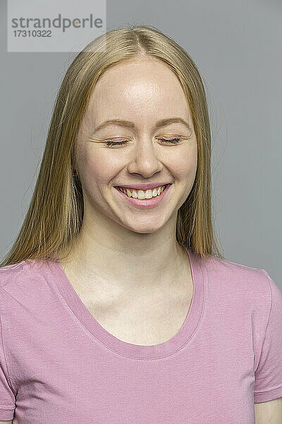 Porträt lachende junge Frau mit geschlossenen Augen