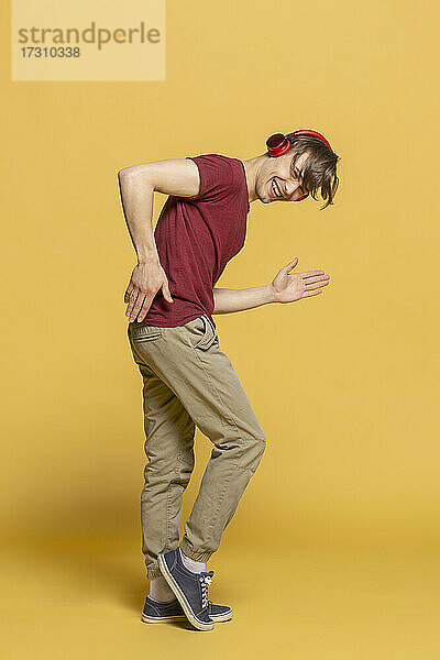 Porträt verspielter junger Mann mit Kopfhörer tanzen