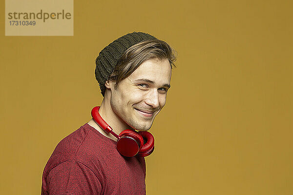 Studio Porträt glücklich junger Mann mit Kopfhörer