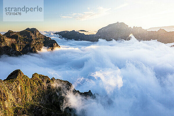 Aus den Wolken auftauchende Berggipfel bei Sonnenuntergang  Blick vom Pico Ruivo  Madeira  Portugal  Atlantik  Europa