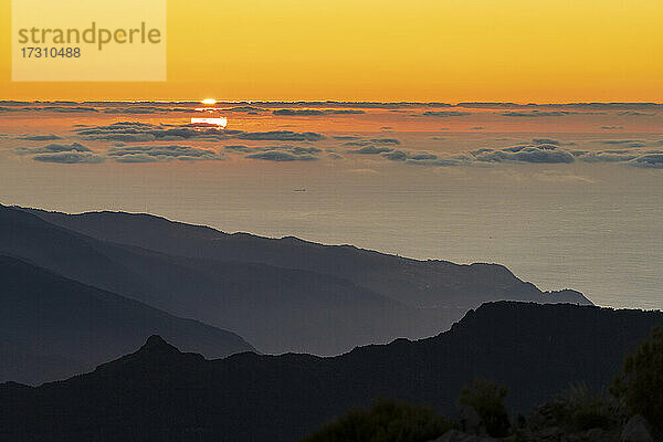 Brennender Himmel bei Sonnenuntergang über dem Atlantischen Ozean und Silhouetten der Berge vom Gipfel des Pico Ruivo  Madeira  Portugal  Atlantik  Europa