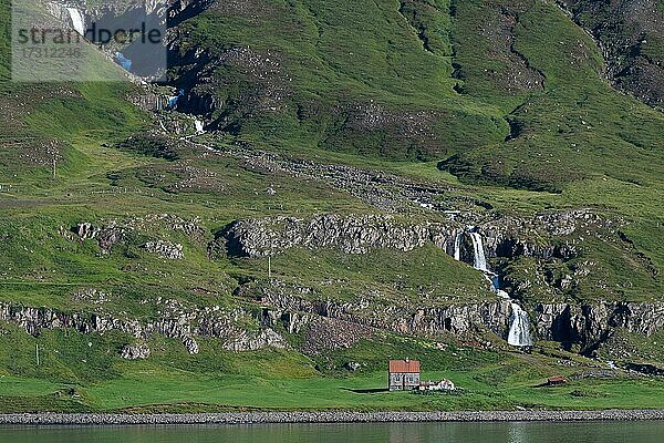 Abgelegener Bauernhof vor einem Wasserfall  Seyðisfjörður  Austurland  Ostisland  Island  Europa