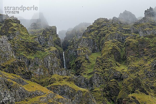 Zerklüftete Berghänge und Wasserfall  bei Skógar oder Skogar  Sudurland  Südisland  Island  Europa