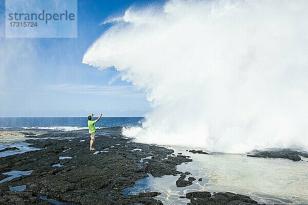 Tourist genießt die riesigen Wellen in den Alofaaga Blowholes im Süden von Savai'i  Südpazifik  Samoa  Ozeanien