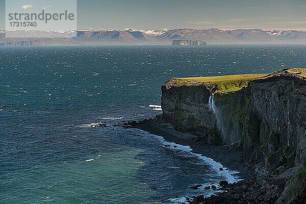 Wasserfall stürzt über Klippe und wird durch Wind verweht  im Hintergrund Saga-Insel Drangey  Halbinsel Skagi  Skagafjörður  Norðurland vestra  Island  Europa
