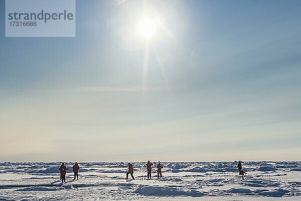 Menschen bei einer Wanderung auf dem Eis des Nordpols  Arktis