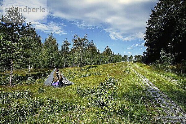 Mann im Zelt  Wanderer campiert  Kolonnenweg  Lochplattenweg  Wanderweg durch Wald  Grünes Band  Grenzweg  ehemalige deutsch-deutsche Grenze  bei Nordhalben  Bayern  Deutschland  Europa