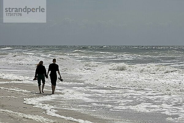 Junges Paar geht am Strand an der Meeresbrandung  Nordsee  Westküste Hörnum  Sylt  Nordfriesland  Schleswig-Holstein  Deutschland  Europa