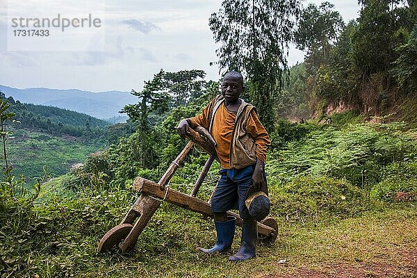 Junge mit seinem selbstgebauten Fahrrad  das nur aus Holz besteht  südliches Uganda