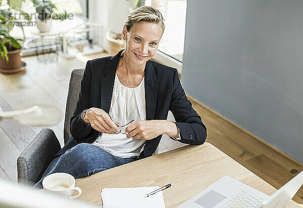 Geschäftsfrau lächelnd beim Sitzen im Büro