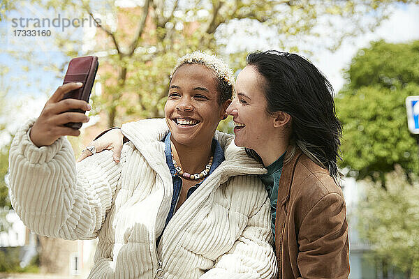 Glückliches lesbisches Paar nimmt Selfie durch Smartphone