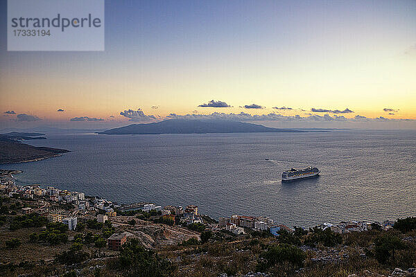 Sonnenuntergang über dem Ionischen Meer mit einem Kreuzfahrtschiff im Hintergrund