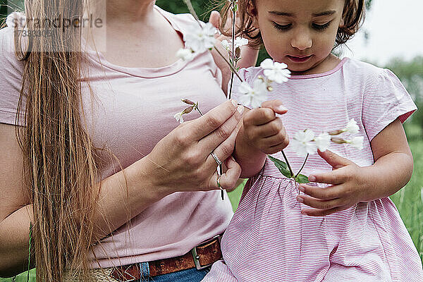 Mutter und Tochter halten Blumen im Park