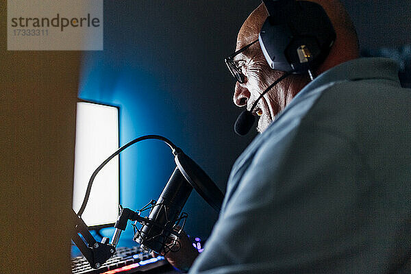 Mann beim Live-Streaming am Computer zu Hause