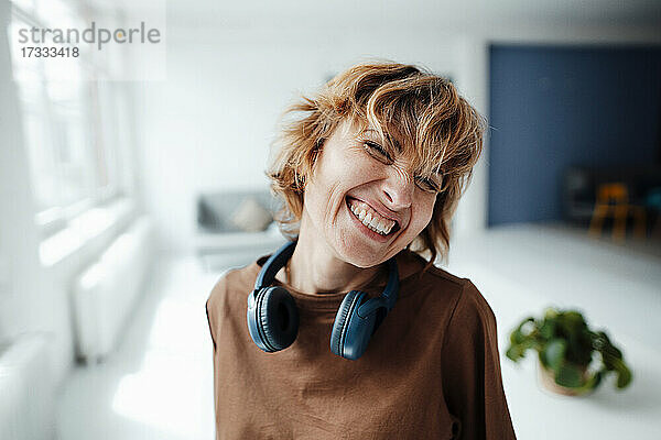 Geschäftsfrau mit Kopfhörern lächelnd im Büro