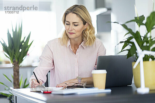 Geschäftsfrau bei der Arbeit am Schreibtisch im Heimbüro