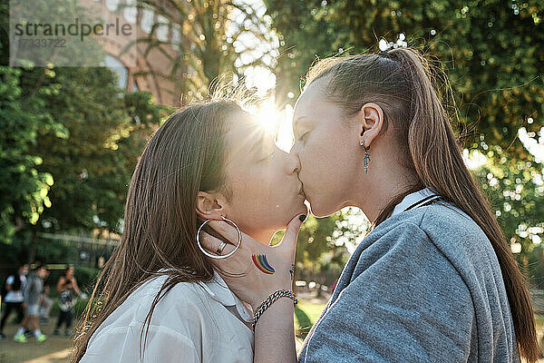 Junges Paar küsst sich im Park auf den Mund