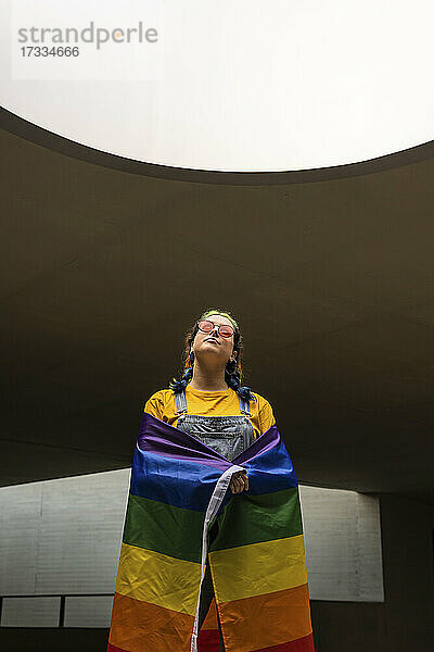 Junge Frau stehend mit Regenbogenflagge