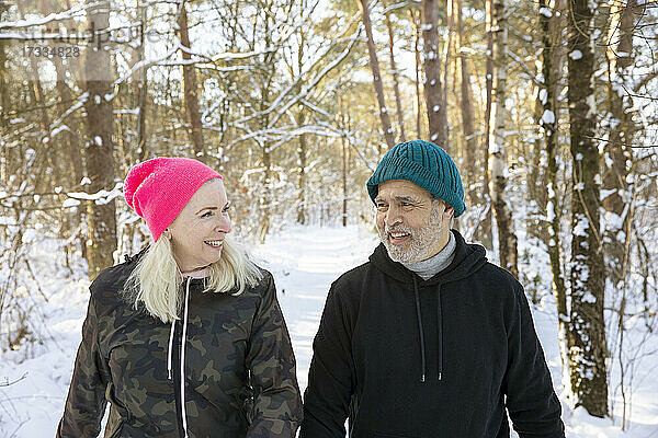 Lächelndes Seniorenpaar im winterlichen Wald