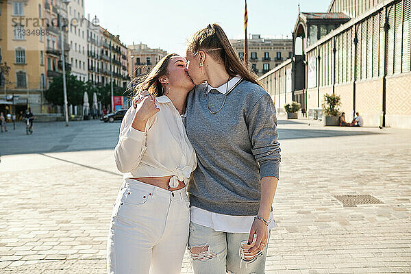 Lesbisches Paar  das sich beim Spaziergang in der Stadt küsst