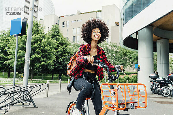 Fröhliche junge Frau beim Radfahren in der Stadt