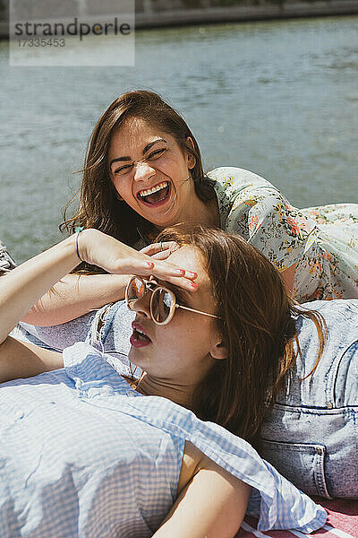 Frau lacht  während ihre Freundin an einem sonnigen Tag wegschaut