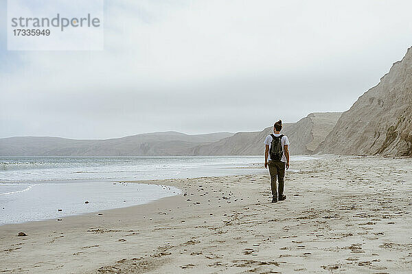 Junger Mann  der am Strand von Point Reyes  Kalifornien  USA  im Sand spazieren geht