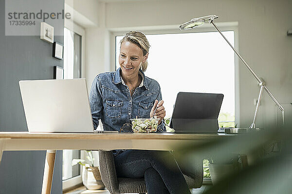 Freiberuflerin mit Laptop im Home-Office sitzend