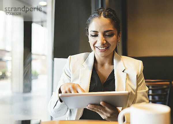 Berufstätige Frau benutzt digitales Tablet in einem Café