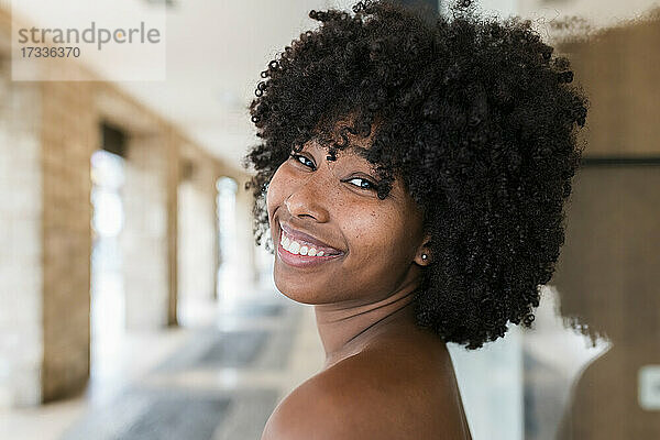 Lächelnde Afro-Frau schaut über die Schulter