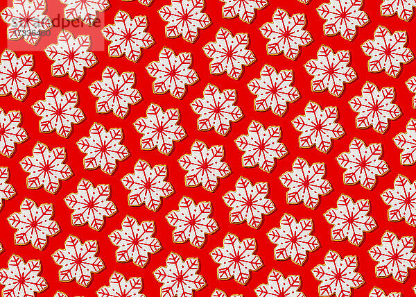 Muster von Schneeflocken förmigen Weihnachtsplätzchen flach gegen lebendigen roten Hintergrund gelegt
