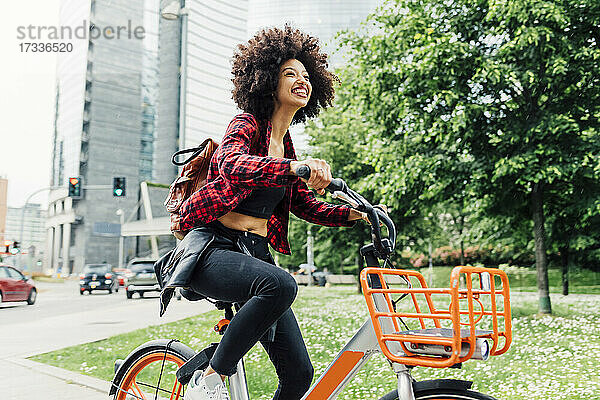 Fröhliche Frau auf dem Fahrrad in der Stadt