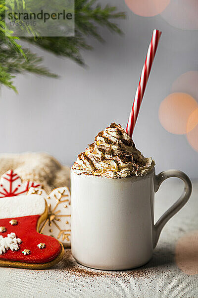 Weihnachtsplätzchen und eine Tasse mit schaumiger heißer Schokolade