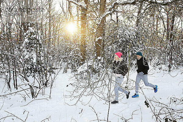 Älterer Mann und Frau laufen im Wald im Winter
