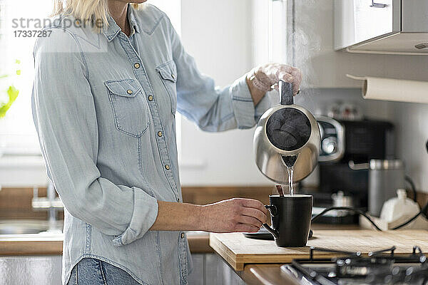 Frau bei der Zubereitung von Tee in der Küche zu Hause