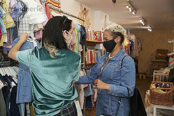 Lesbische Frauen beim Einkaufen von Kleidung in einem Geschäft während der COVID-19
