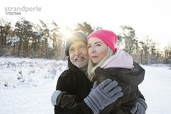 Älteres Paar in warmer Kleidung  das sich im Winter umarmt