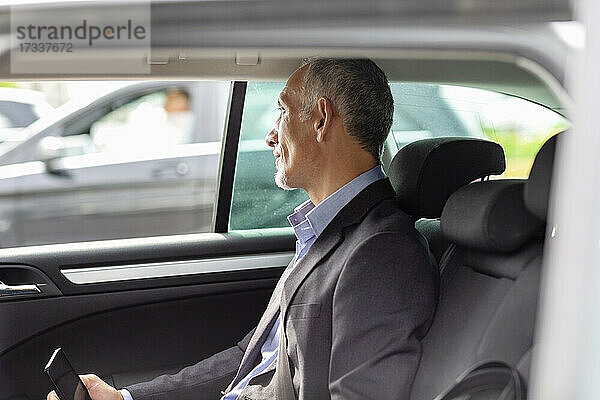Männlicher Berufstätiger schaut durch das Fenster  während er im Auto sitzt