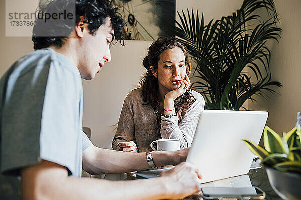 Ehepaar arbeitet zu Hause gemeinsam am Laptop