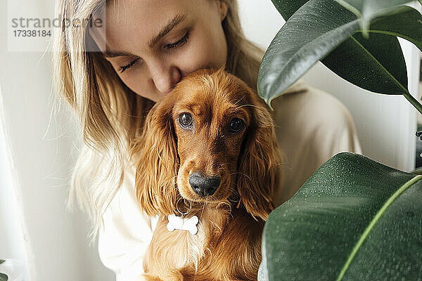 Frau küsst Cocker Spaniel Hund zu Hause