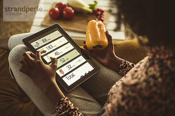 Frau plant Diät mit digitalem Tablet zu Hause