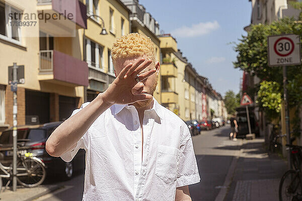Deutschland  Köln  Albino-Mann im weißen Hemd auf der Straße