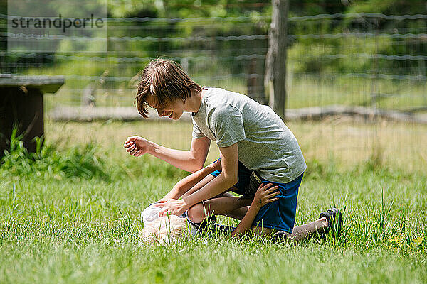 Kanada  Ontario  Kingston  Junge (8-9) spielt mit Bruder auf Gras