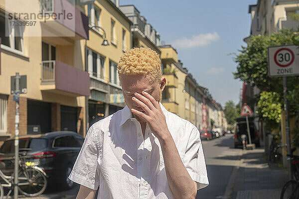 Deutschland  Köln  Albino-Mann im weißen Hemd auf der Straße