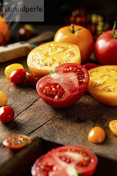 Halbierte gelbe und rote Tomaten auf Holzschneidebrett