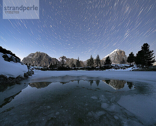 Polarsternspur am Nachthimmel über den Gipfeln des Lagazuoi und der Tofana di Rozes vom zugefrorenen Limides-See aus  Dolomiten  Venetien  Italien  Europa