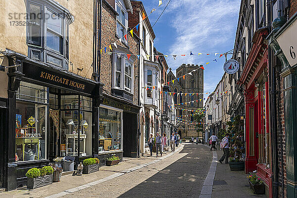 Blick auf Geschäfte und Cafés in der Kirkgate und die Kathedrale im Hintergrund  Ripon  North Yorkshire  England  Vereinigtes Königreich  Europa