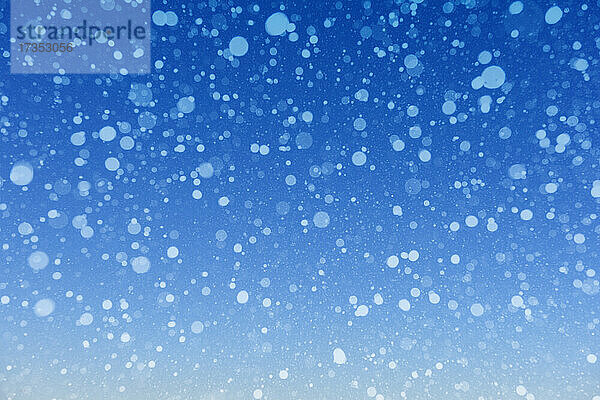 Fallender Schnee vor blauem Hintergrund