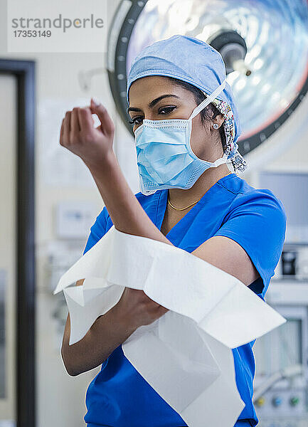 Ärztin bereitet sich im Operationssaal auf eine Operation vor