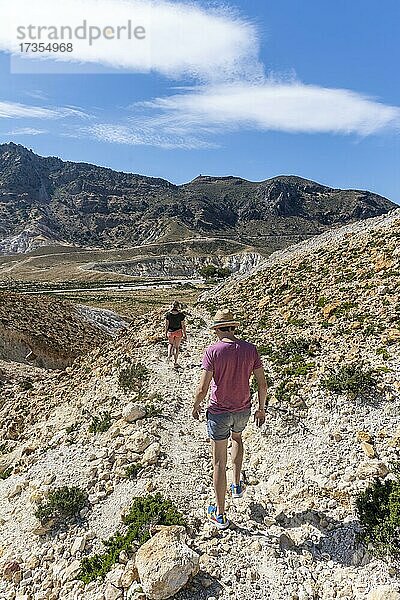 Drei Touristen wandern in einer Vulkan Caldera mit Bimssteinfeldern  gelb gefärbte Schwefelsteine  Alexandros Krater  Nisyros  Dodekanes  Griechenland  Europa
